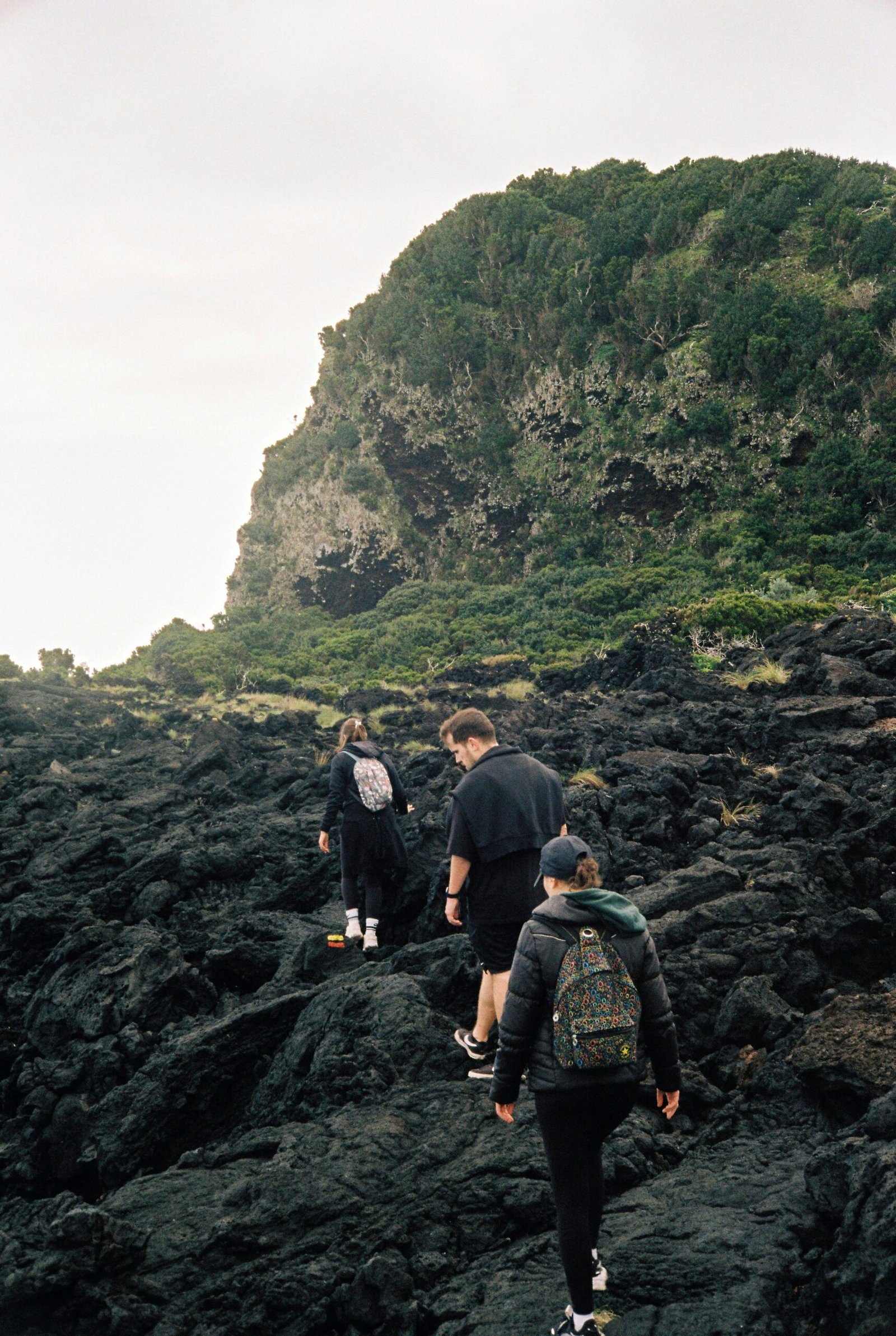 a group of people walking up a rocky hill